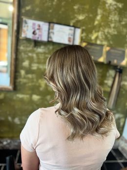 Achteraanzicht van lang, warm kastanjebruin haar met grote glam waves, gecreëerd door Anthe van Salon Couleur.
