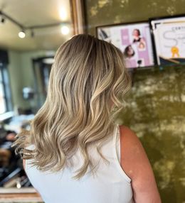 Achteraanzicht van lang, recht uitgeföhnd koel beige/ashy bruin haar met blunt-cut punten, afgewerkt door Anthe van Salon Couleur.