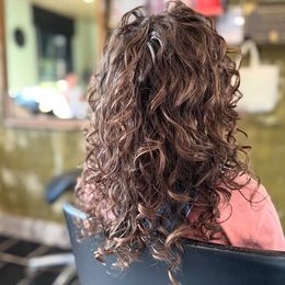 Achteraanzicht van halflang ash-blond haar met zachte waves en subtiele balayage, gemaakt door Anthe van Salon Couleur.