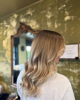 Achteraanzicht van lange, veerkrachtige bruine krullen met natuurlijke glans, geknipt en gestyled door Anthe van Salon Couleur.